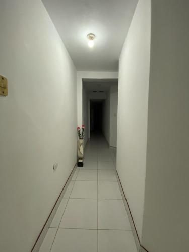 - un couloir aux murs blancs et des toilettes dans la chambre dans l'établissement Habitación Céntrica, à Chiclayo