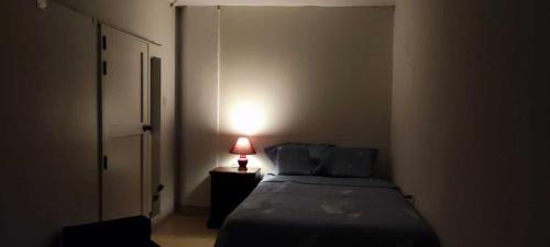 - une chambre avec un lit et une lampe sur une table de chevet dans l'établissement Habitación Céntrica, à Chiclayo