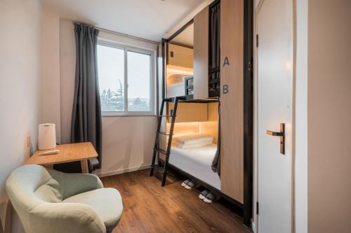 a small room with a bunk bed and a chair at Joy Hongqiao Airport and Railway Hotel in Shanghai