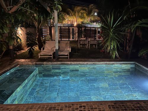 a pool at night with chairs and palm trees at Tropical 3-bedrooms Coastal Residence Creolia2 in Pointe aux Cannoniers