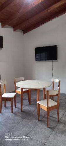 uma mesa e duas cadeiras e uma televisão na parede em La posada del viento em Villa El Rincón