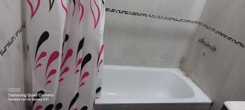 uma cortina de chuveiro com um design vermelho e preto na casa de banho em La posada del viento em Villa El Rincón