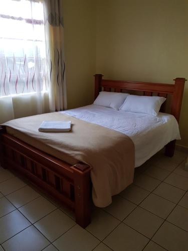 a bed in a bedroom with a tray on it at Jari Inn Bistro in Ngong