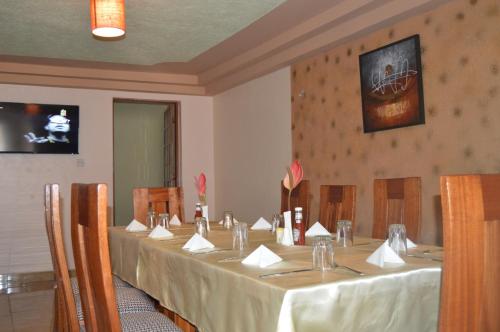 een vergaderruimte met een lange tafel met witte tafellakens bij Jari Inn Bistro in Ngong