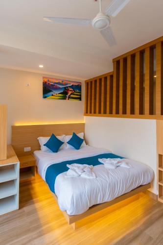 a bedroom with a large bed with blue pillows at POKHARA APARTMENTS INN in Pokhara