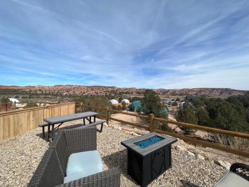 eine Terrasse mit einem Tisch, Stühlen und einem Grill in der Unterkunft Bryce Glamp And Camp in Cannonville