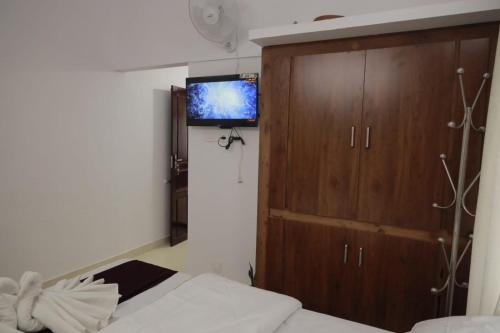 a bedroom with a bed and a tv on the wall at Heaven's homestay in Parūr