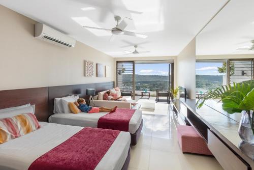1 Schlafzimmer mit 2 Betten und 1 Kind auf dem Bett in der Unterkunft The Terraces Boutique Apartments in Port Vila