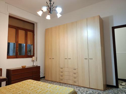a bedroom with a large wooden cabinet and a bed at Casa Bonaria - IUN R 6698 in SantʼAntìoco