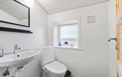 a white bathroom with a sink and a toilet at Five-Bedroom Holiday Home In Kibak in Ørbæk