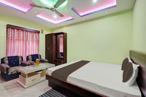 a bedroom with a bed and a table and chairs at OYO Flagship Hotel Maa Bharati in Guwahati