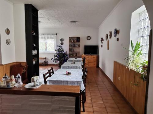 a dining room with three tables and a television at Fenyő Vendégház in Parádsasvár