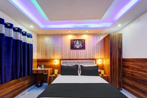 a bedroom with a bed with a blue light on the ceiling at Collection O Hotel Royal Sangrila in Patna
