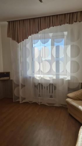 a window with white curtains in a living room at Колливинг на Республике (золотой квадрат) in Astana