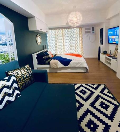 1 dormitorio con cama, sofá y TV en Paris Themed Condo in BGC (by The Fort Strip), en Manila
