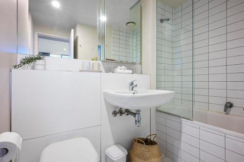a bathroom with a sink and a toilet and a mirror at Collins Street City Stay - 2 Min to Southern Cross in Melbourne