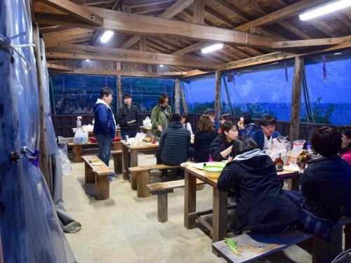 een groep mensen die aan tafel zitten in een restaurant bij Tonosaki Bungalow & BBQ - Vacation STAY 29542v in Tsushima