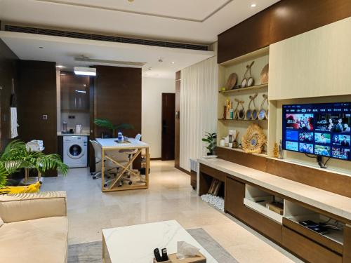 a living room with a large television and a living room with a couch at 邻致公寓东站中汇店 in Guangzhou