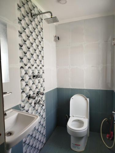La salle de bains est pourvue de toilettes et d'un lavabo. dans l'établissement Godawari villa guest house, à Godāvari