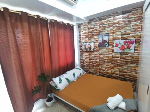 a small room with a brick wall and a bench at Modern 1BR with balcony and 100mbps wifi in Manila