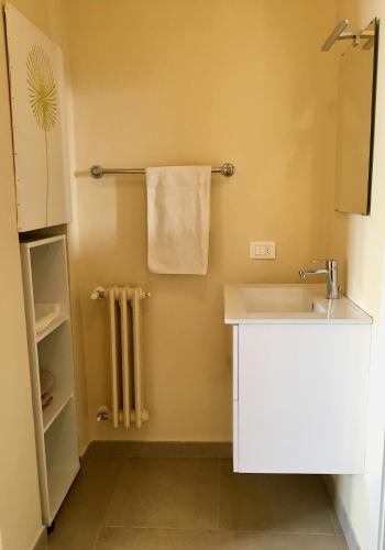 a small bathroom with a sink and a towel at Casa con ampio terrazzo, vista lago e giardino in Toscolano Maderno