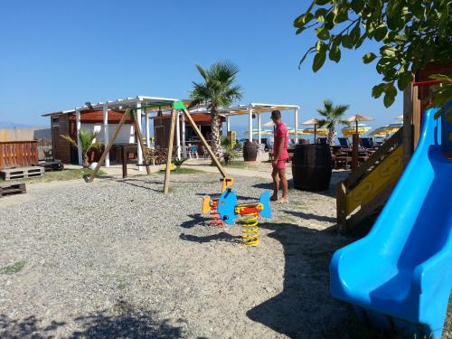 een man die voor een speeltuin staat bij Hotel Poseidon in Corigliano Calabro