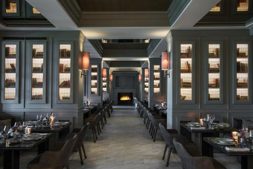 una sala da pranzo con tavoli e sedie e un camino di Princes' Palace Resort, Buyukada - Member of The Leading Hotels of the World a Adalar