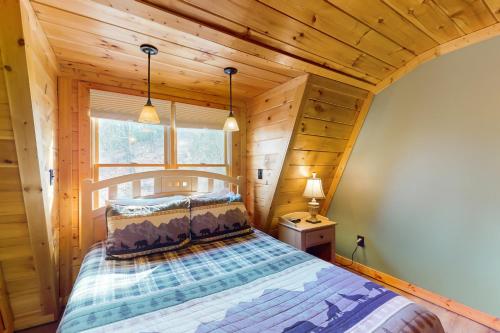 ein Schlafzimmer mit einem Bett in einem Blockhaus in der Unterkunft The Wolf Den in Ranger