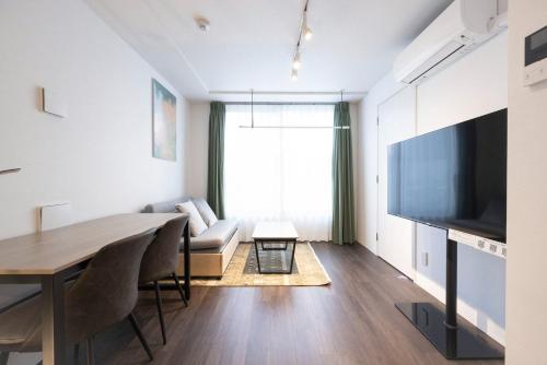 a living room with a table and a large television at LEGA LAND Hatagaya in Tokyo