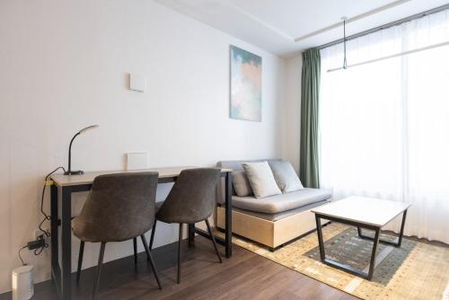 a living room with a couch and a table and chairs at LEGA LAND Hatagaya in Tokyo