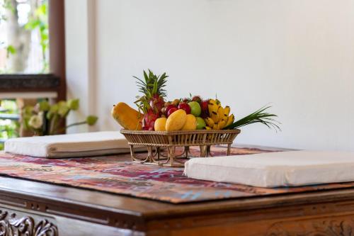 a bowl of fruit on top of a table at Atoh's Maison in Siem Reap