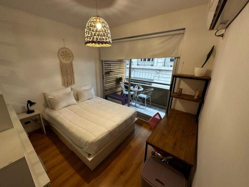 a bedroom with a bed and a table and a window at Av Julio A Roca - Monserrat in Buenos Aires