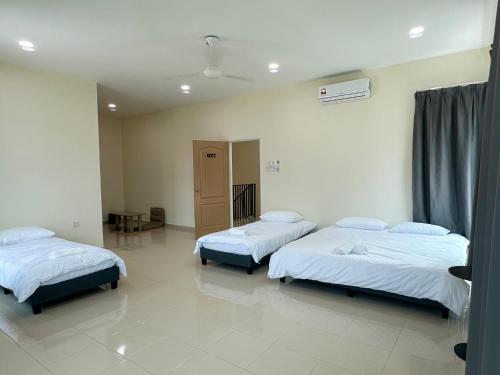 ein Krankenhauszimmer mit 2 Betten und einem Tisch in der Unterkunft Fourteen Homestay in Port Dickson