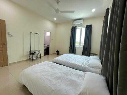 a bedroom with two beds and a mirror at Fourteen Homestay in Port Dickson
