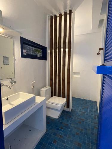 a bathroom with a white sink and a toilet at Chalaroste Place by SMS Hospitality in Bolinao