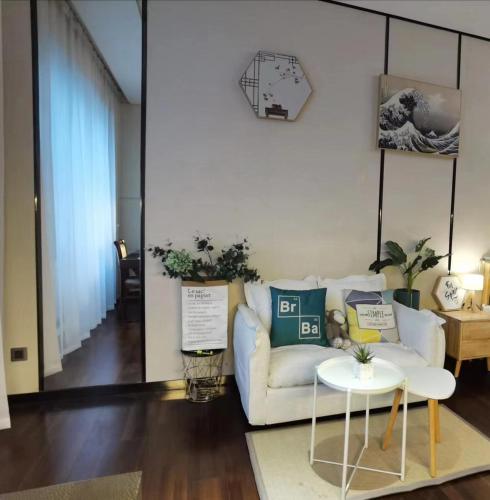 a living room with a white couch and a table at 邻致公寓东站中汇店 in Guangzhou