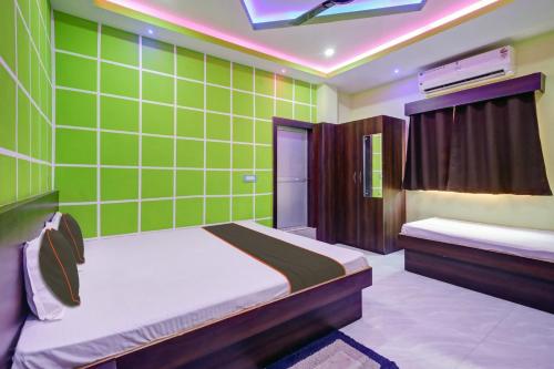 a room with two beds and a green tiled wall at OYO Flagship Hotel Maa Bharati in Guwahati