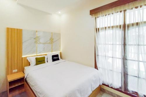 Tempat tidur dalam kamar di Urbanview Hotel Tritia Lampung