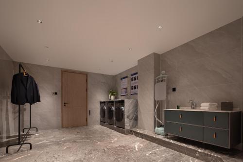 a bathroom with three washing machines and a sink at Howard Johnson Airport Serviced Residence Changsha in Changsha