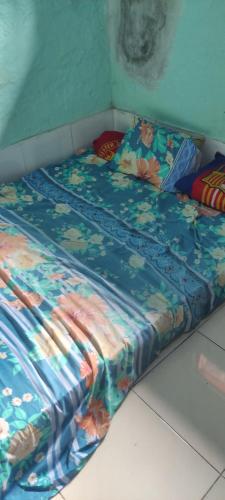 ein Bett mit einer bunten Bettdecke darüber in der Unterkunft Kostel Al-Barokah 