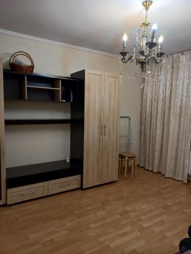 uma sala de estar com um armário e um lustre em Almaly em Almaty
