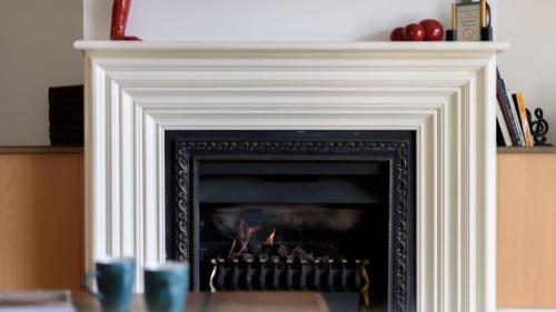 a fireplace with a fire inside of it at Lakeside Suite 2 - Lake View & Spa Bath in Daylesford
