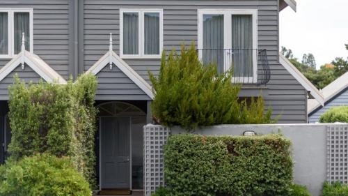 a gray house with a gate and bushes at Lakeside Suite 4 - Lake View & Spa Bath in Daylesford