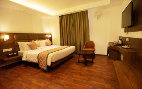 a hotel room with a bed and a desk at NAR Comforts in Bangalore
