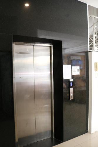 a metal elevator in a room with a black wall at Diamond Crown in Patong Beach