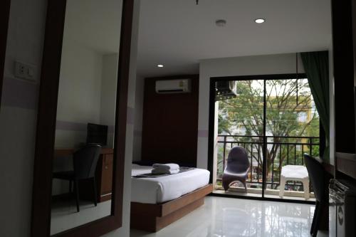 a bedroom with a bed and a view of a balcony at Diamond Crown in Patong Beach