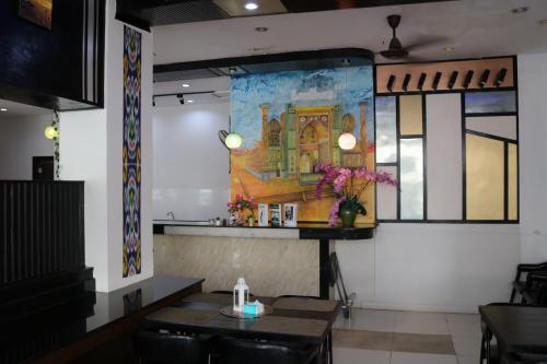 a dining room with tables and a painting on the wall at Diamond Crown in Patong Beach