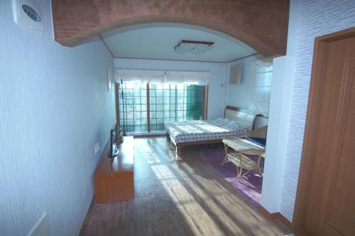 a bedroom with a bed and a table in a room at Yerae Pension in Seogwipo