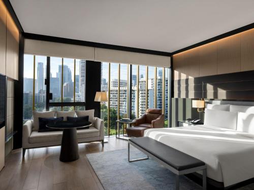 InterContinental Singapore Robertson Quay, an IHG Hotel في سنغافورة: غرفة فندقية بسرير ونافذة كبيرة