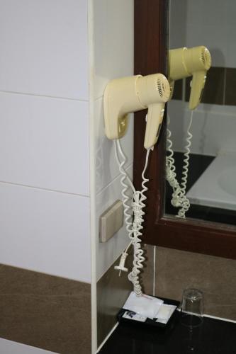 a phone hanging on a wall next to a mirror at Diamond Crown in Patong Beach
